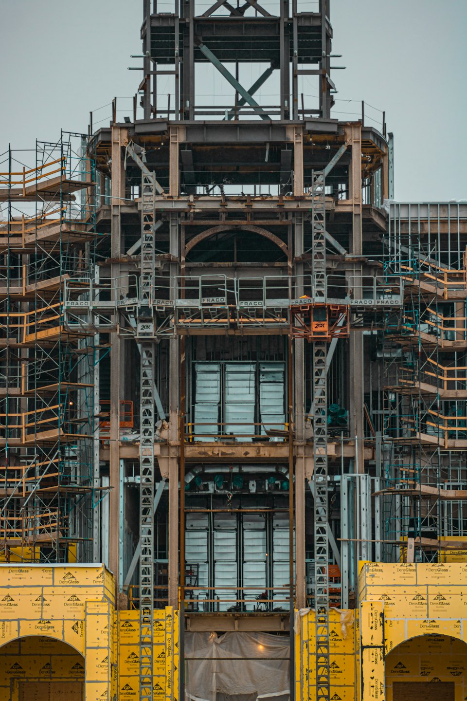 Building under construction with steel framework and yellow sheathing.