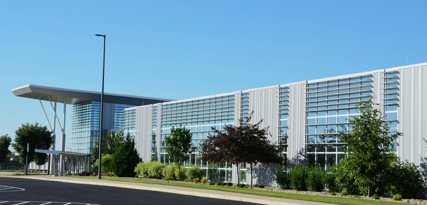 Modern commercial building with glass walls and metal paneling.